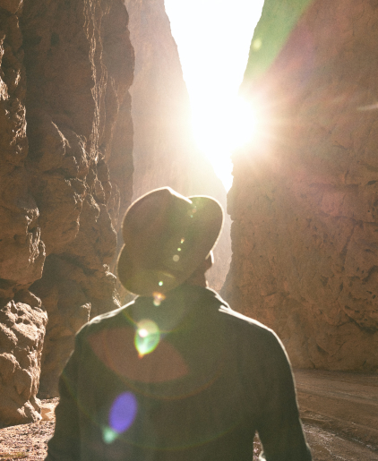 Person Hiking Through Canyons