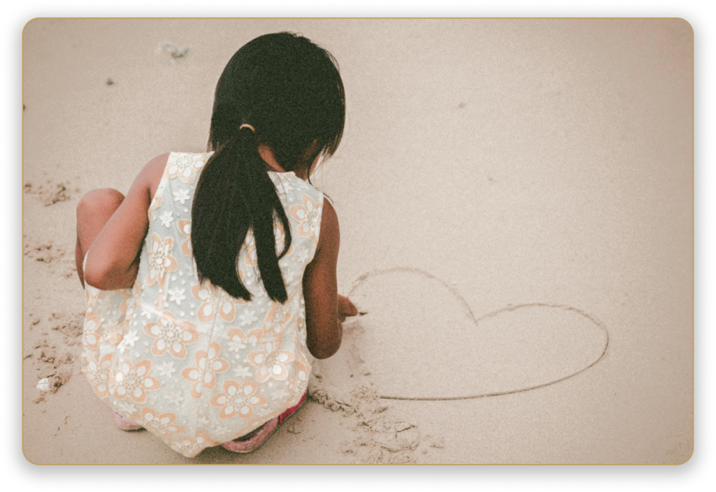 girl making a heart in the sand